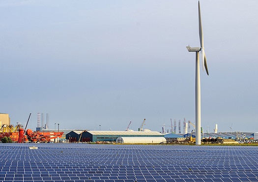 Zonnepark met windmolen op achtergrond